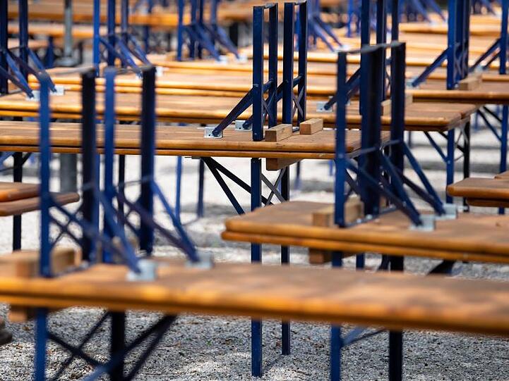 Menschenleer zeigt sich ein Biergarten mit gestapelten Bänken und Tischen im Münchner Westpark. Foto: Sven Hoppe/dpa/Archivbild