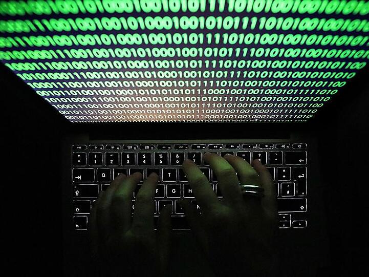Auf dem Bildschirm eines Laptops ist Binärcode zu sehen. Foto: Oliver Berg/Archivbild