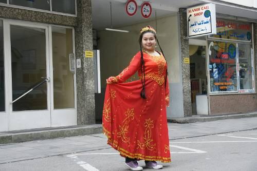 Eine Frau posiert für die AZ in typischer Tracht vorm uigurischen Gemeindezentrum.