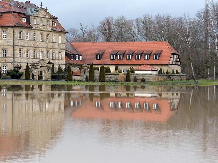 Die Seniorenresidenz Schloss Gleusdorf spiegelt sich in einer überfluteten Wiese. Foto: David-Wolfgang Ebener