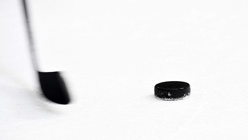 Ein Puck und ein Eishockeyschläger.