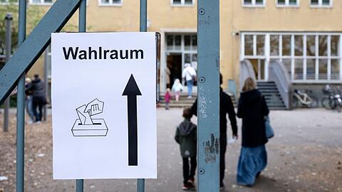 Ein Schild mit der Aufschrift "Wahlraum" hängt an einem Tor vor einem Wahllokal im Stadtteil München-Neuhausen.