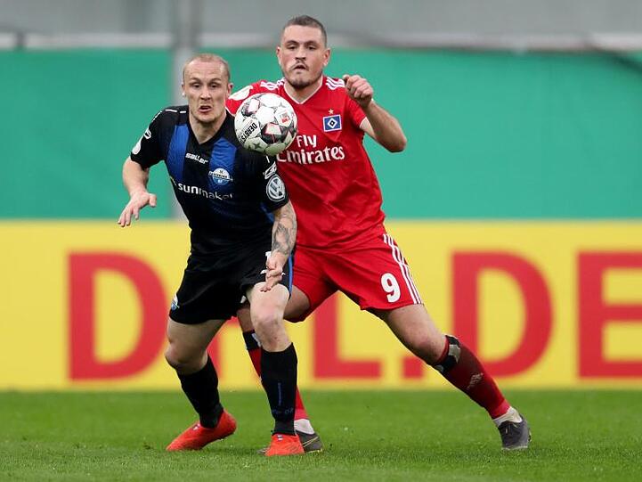 Der Paderborner Sven Michel (l) im Kampf um den Ball mit Kyriakos Papadopoulos aus Hamburg. Foto: Friso Gentsch/Archiv
