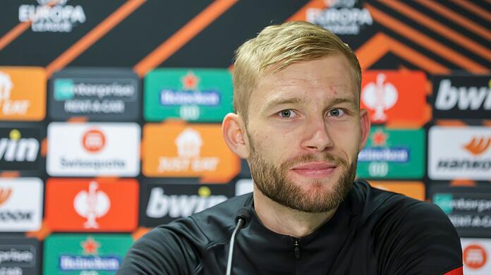 Leipzigs Spieler Konrad Laimer sitzt in der Pressekonferenz.