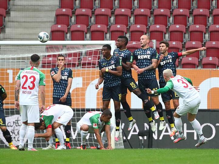 FC Augsburgs Philipp Max schießt den Freistoß über die Mauer aufs Tor.