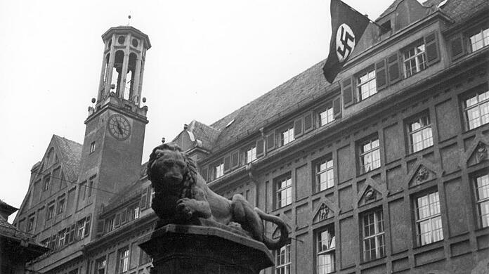 März 1933: Machtergreifung der Nationalsozialisten in Bayern. Am Gebäude der Polizeidirektion in der Ettstraße weht eine Hakenkreuzfahne.