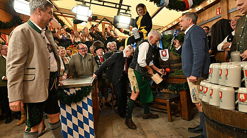 Wiesn-like: Dieter Reiter (SPD, 3.v.r), Oberbürgermeister von München, steht neben Helmut Huber (4.v.r), Schankmeister, und Markus Söder (CSU, l), Ministerpräsident von Bayern, und sticht das erste Oktoberfestfass im Schottenhamel-Festzelt an.