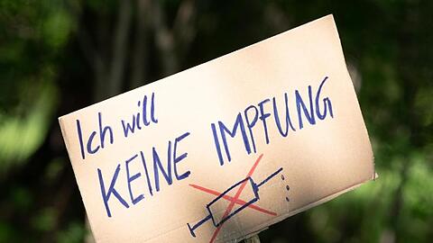 Ein Schild mit der Aufschrift "Ich will keine Impfung" am Rande einer Kundgebung in Dresden.