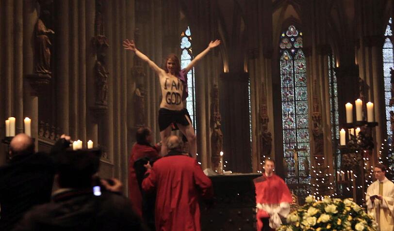 Femen-Aktivistin Josephine Witt springt am ersten Weihnachtsfeiertag nackt auf den Altar des Kölner Doms.