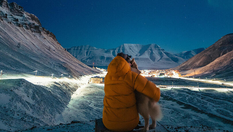 Influencerin Cecilia Blomdahl mit ihrem Hund Grim. Während der Polarnacht kann man auf Spitzbergen Nordlichter beobachten.