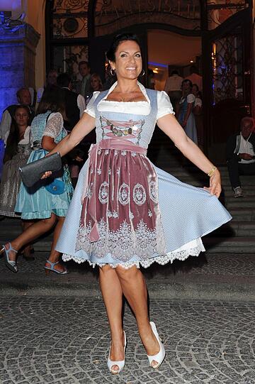 Modekönigin Christine Neubauer erscheint in traditionellem weiß-blau.