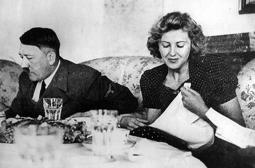 Adolf Hitler mit seiner Lebensgefährtin Eva Braun beim gemeinsamen Essen auf einer undatierten Aufnahme: Von beiden werden Teile aus ihrem ehemaligen Besitz, so etwa auch Kleidung, versteigert.