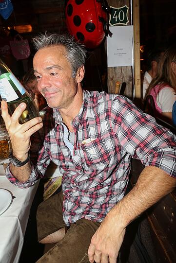 Der Schauspieler Hannes Jaenicke bestaunt ein Getränk, das für die Wiesn eher ungewöhnlich ist: Mineralwasser.