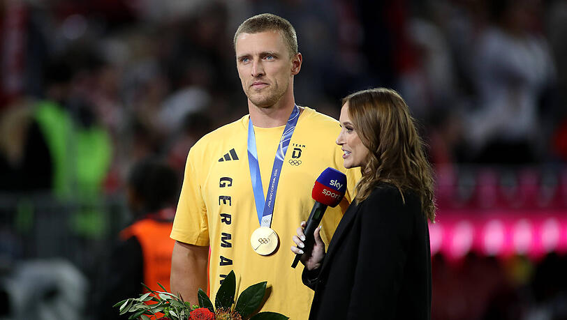 Bob-Anschieber Thorsten Margis wurde gemeinsam mit anderen Olympiamedaillengewinnern von 2026 vor dem Spiel in der Allianz Arena geehrt. Bob-Anschieber Thorsten Margis wurde gemeinsam mit anderen Olympiamedaillengewinnern von 2026 vor dem Spiel in der Allianz Arena geehrt.