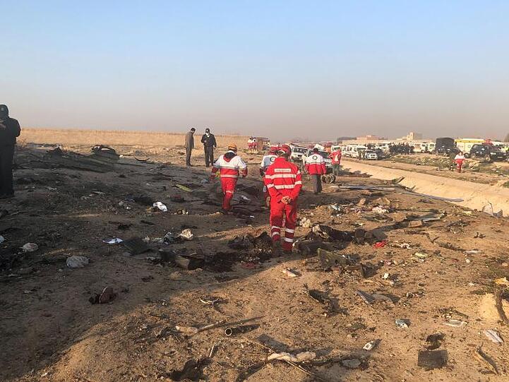 Rettungskräfte stehen am Ort eines Flugzeugabsturzes am Rande von Teheran. Bei dem Absturz der ukrainischen Passagiermaschine nahe Teheran sind nach Angaben der Hilfsorganisation iranischer Halbmond alle Insassen ums Leben gekommen.