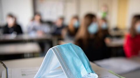 Eine Maske liegt auf einem Tisch in einer Münchner Schule.