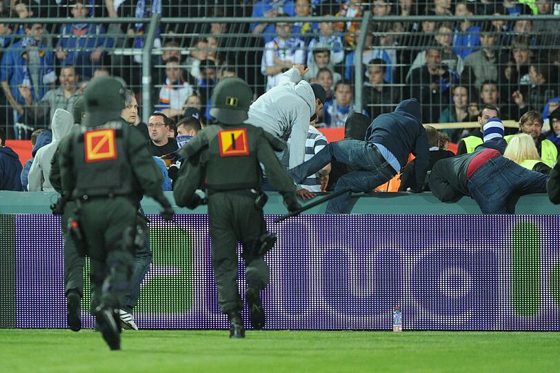 Fans, die das Feld stürmen wollten, werden von den Polizisten in Schach gehalten.