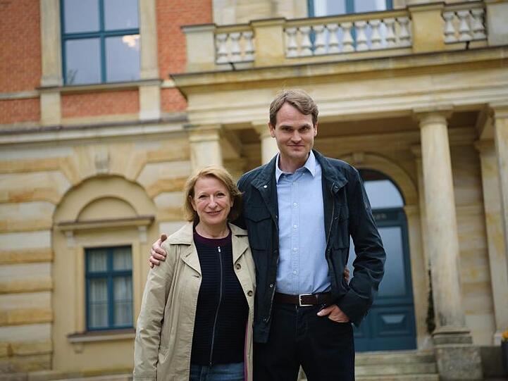 Die Schauspieler Dagmar Manzel und Fabian Hinrichs stehen vor dem Bayreuther Festspielhaus. Foto: Nicolas Armer/Archiv