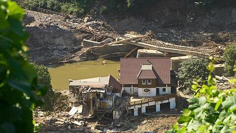 Ein Haus in Marienthal ist nach dem Hochwasser vollkommen aufgerissen, dahinter ist eine zerstörte Brücke zu sehen.