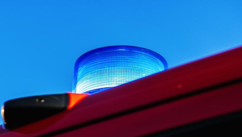 Das Blaulicht leuchtet auf dem Dach eines Feuerwehrfahrzeugs.