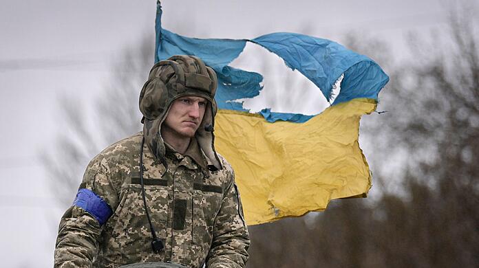 Ein ukrainischer Soldat steht auf einem Panzer au&szlig;erhalb von Kiew.