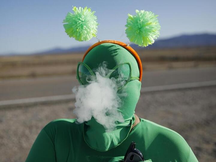 Ein als Alien verkleideter Besucher des Festivals vor dem Eingang zu Area 51.