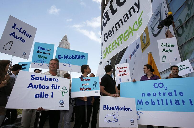 Mit Protest-Plakaten machen die Greenpeace-Aktivisten ihrem Unmut über den neuen Kleinwagen "VW Up" auf der Internationalen Automobilausstellung in Frankfurt Luft.