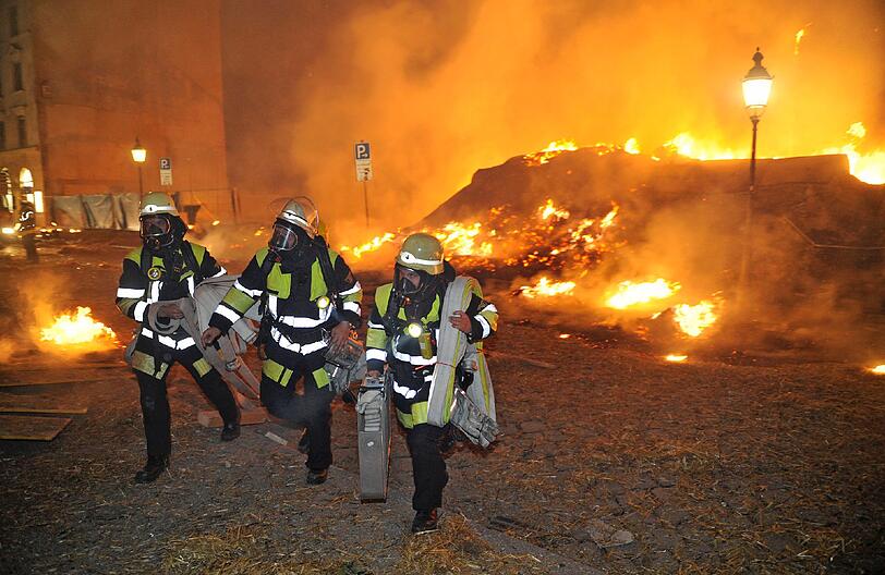Feuer, Rauch, zerborstene Fenster - nach der Sprengung der Bombe hat die Feuerwehr viel zu tun: Umherfliegendes Stroh hatte Brände verursacht.