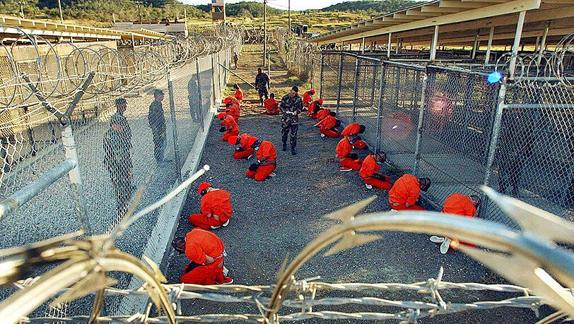 Das von der US-Armee herausgegebene Archivfoto zeigt Häftlinge, die im Camp X-Ray auf dem US-Marinestützpunkt Guantanamo Bay auf Kuba auf dem Boden knien. Das von der US-Armee herausgegebene Archivfoto zeigt Häftlinge, die im Camp X-Ray auf dem US-Marinestützpunkt Guantanamo Bay auf Kuba auf dem Boden knien.