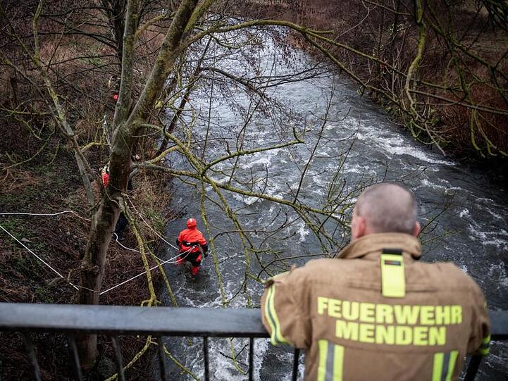 Ein Feuerwehrmann schaut auf den Fluss.