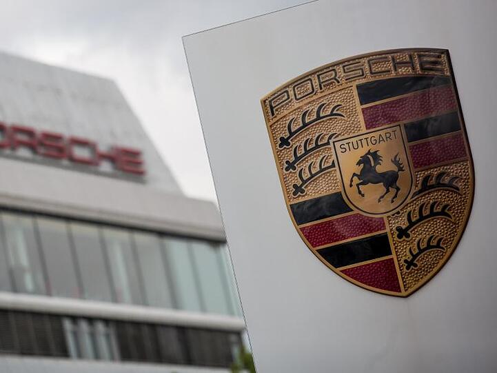 Das Porsche Logo ist vor einem Gebäude des Automobilherstellers zu sehen. Foto: Christoph Schmidt/dpa/Symbolbild