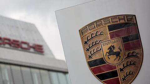 Das Porsche Logo ist vor einem Gebäude des Automobilherstellers zu sehen. Foto: Christoph Schmidt/dpa/Symbolbild