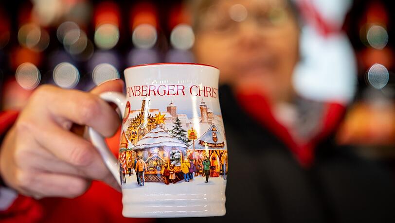 Weihnachtsmotive zieren die offizielle diesjährige Glühwein-Tasse vom Nürnberger Christkindlesmarkt. Und der Glühwein darin? Müsste vielerorts eigentlich 20 Euro kosten, wenn die Marktbeschicker nicht so viel selbst machen würden beim Standlauf- und Abbau, heißt es. Weihnachtsmotive zieren die offizielle diesjährige Glühwein-Tasse vom Nürnberger Christkindlesmarkt. Und der Glühwein darin? Müsste vielerorts eigentlich 20 Euro kosten, wenn die Marktbeschicker nicht so viel selbst machen würden beim Standlauf- und Abbau, heißt es.