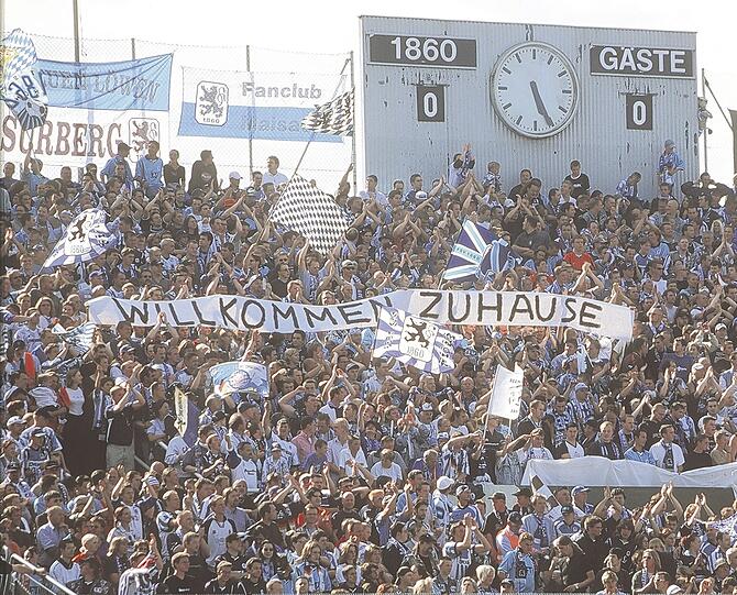 Heimat ist, wo die Anzeigentafel noch von Hand verstellt werden muss: Die Löwen-Fans in der legendären Westkurve des Städtischen Stadions an der Grünwalder Straße, wie das Sechzger offiziell heißt.