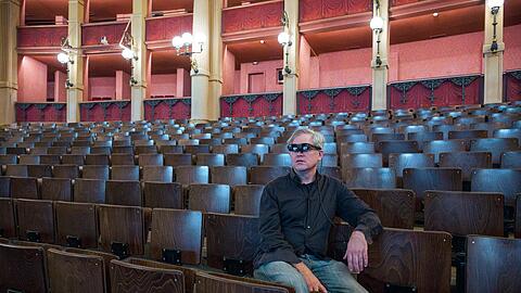 Jay Scheib sitzt mit einer Augmented Reality Brille im Zuschauerraum des Festspielhauses.