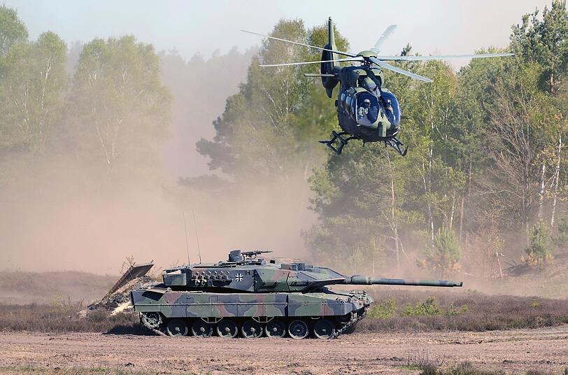 Teuer und veraltet? - Ein Panzer vom Typ Leopard 2 A6 und ein Hubschrauber vom Typ EC 135 demonstrieren ihre Fähigkeiten. Teuer und veraltet? - Ein Panzer vom Typ Leopard 2 A6 und ein Hubschrauber vom Typ EC 135 demonstrieren ihre Fähigkeiten.
