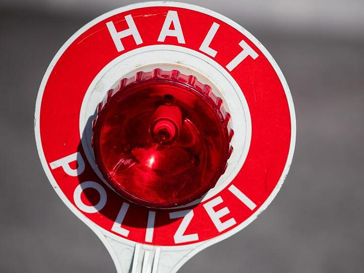 "Halt Polizei" steht auf einer Polizeikelle. Foto: Daniel Karmann/Archiv
