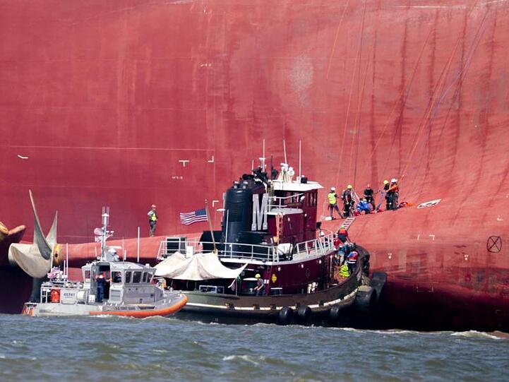 Rettungskräfte arbeiten in der Nähe des Hecks des Frachtschiffs "Golden Ray", welches mit Schlagseite im Meer liegt.
