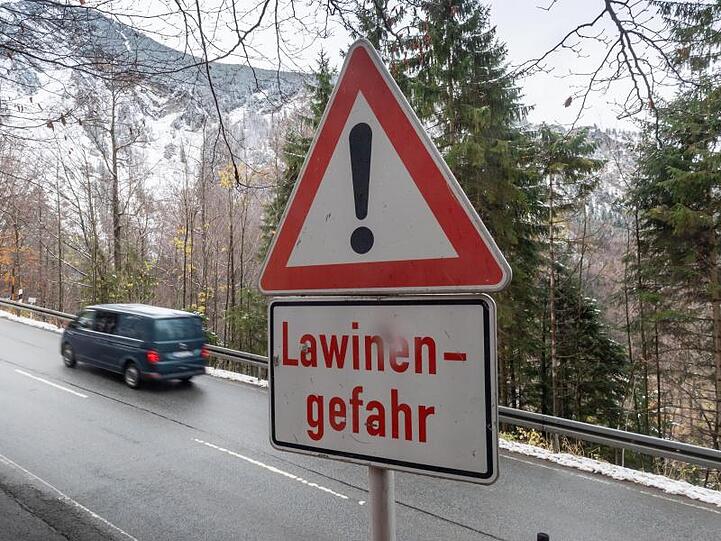 Ein Schild mit der Aufschrift "Lawinengefahr" steht an einer Straße. Foto: Peter Kneffel/dpa/Archivbild