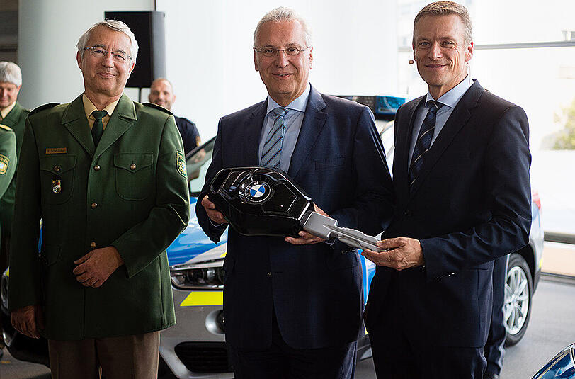 Bayerns Innenminister Joachim Herrmann (CSU, .) am Donnerstag bei der symbolischen Schlüsselübergabe für die neuen blauen Dienstfahrzeuge der Polizei in der BMW-Welt. Neben ihm stehen Landespolizeipräsident Wilhelm Schmidbauer (l.) und Peter van Binsbergen, Vertriebsleiter von BMW in Deutschland.