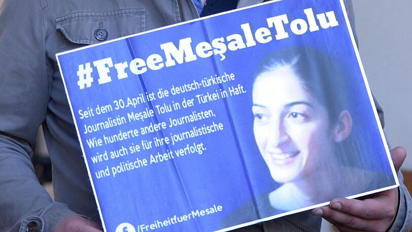 Hüseyin Tolu hält ein Schild in den Händen, auf dem die Freilassung seiner in der Türkei inhaftierten Schwester Mesale Tolu Corlu gefordert wird.