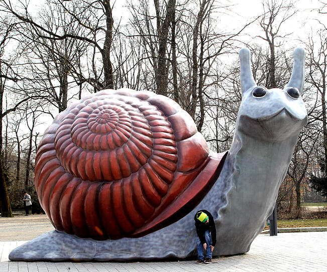 Schnecke trifft Zwergerl: Das riesige Weichtier steht am Rande des Bavariaparks &ndash; und wirkt gut gelaunt.