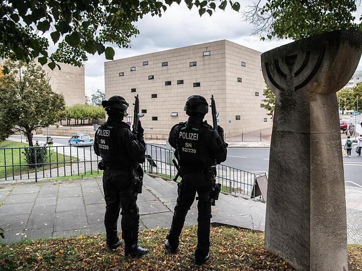 Polizisten stehen mit automatischen Waffen vor der Dresdener Synagoge.