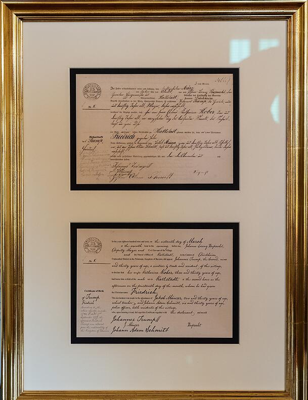In dem goldenen Rahmen findet sich ein Faksimile der Geburtsurkunde von Trumps Großvater Friedrich, der später in die USA auswanderte und seinen Namen in Frederick änderte – und eine englische Übersetzung. In dem goldenen Rahmen findet sich ein Faksimile der Geburtsurkunde von Trumps Großvater Friedrich, der später in die USA auswanderte und seinen Namen in Frederick änderte – und eine englische Übersetzung.