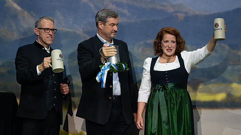 Christian Dahncke (l-r), Paulaner-Braumeister, Markus Söder (CSU), Ministerpräsident von Bayern, und Luise Kinseher, Kabarettistin, stehen beim Starkbieranstich auf dem Nockherberg auf der Bühne. Mit dem traditionellen Verspotten, dem "Derblecken" von Politikern am Münchner Nockherberg, wird traditionell die Starkbier-Saison in Bayern eröffnet.