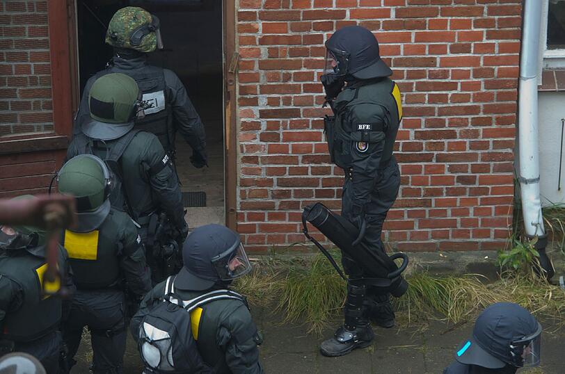 Die Besetzer werfen Konfetti, unten steht ein SEK-Kommando der Polizei: In Greifswald wurde ein besetztes Haus geräumt. Die Bilder.