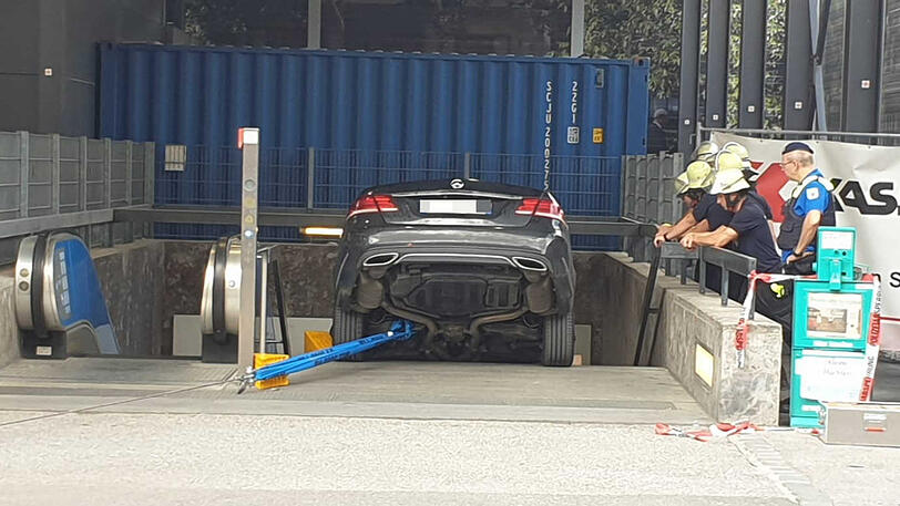 Ein Mercedes von unten. Die Feuerwehr hat das Fahrzeug mit einem Stahlseil gesichert.