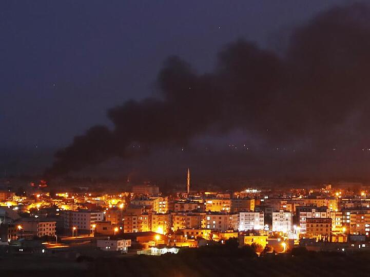 Auf dem von der türkischen Seite der Grenze aufgenommenen Foto ist Rauch zu sehen, der über der syrischen Stadt Ras al-Ain aufsteigt.