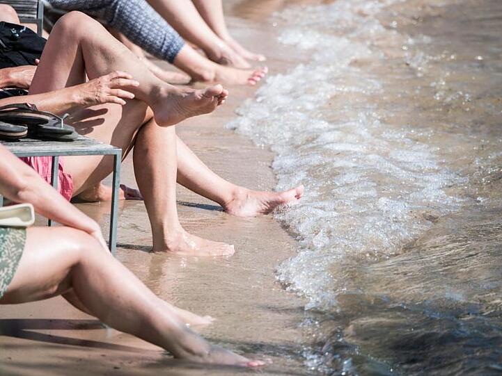 Ab ans Wasser: Menschen kühlen sich Mainz-Kastel am Rheinufer ab.