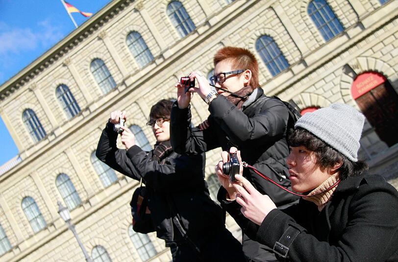 Japanische Touristen fotografieren am Münchner Max-Joseph-Platz vor dem Nationaltheater. Bayern war 2013 als Reiseziel beliebter denn je.